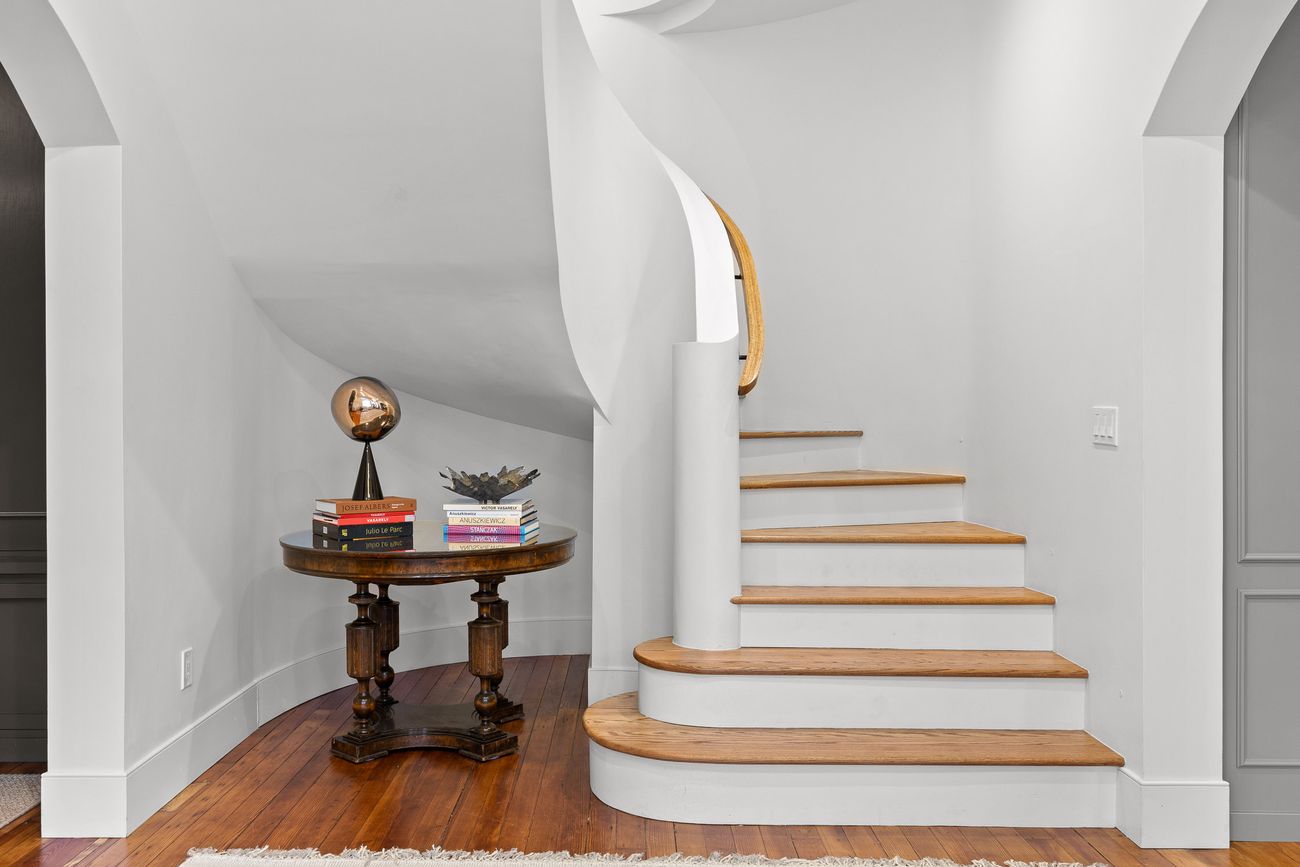 Sculptural staircase rising through the restored home