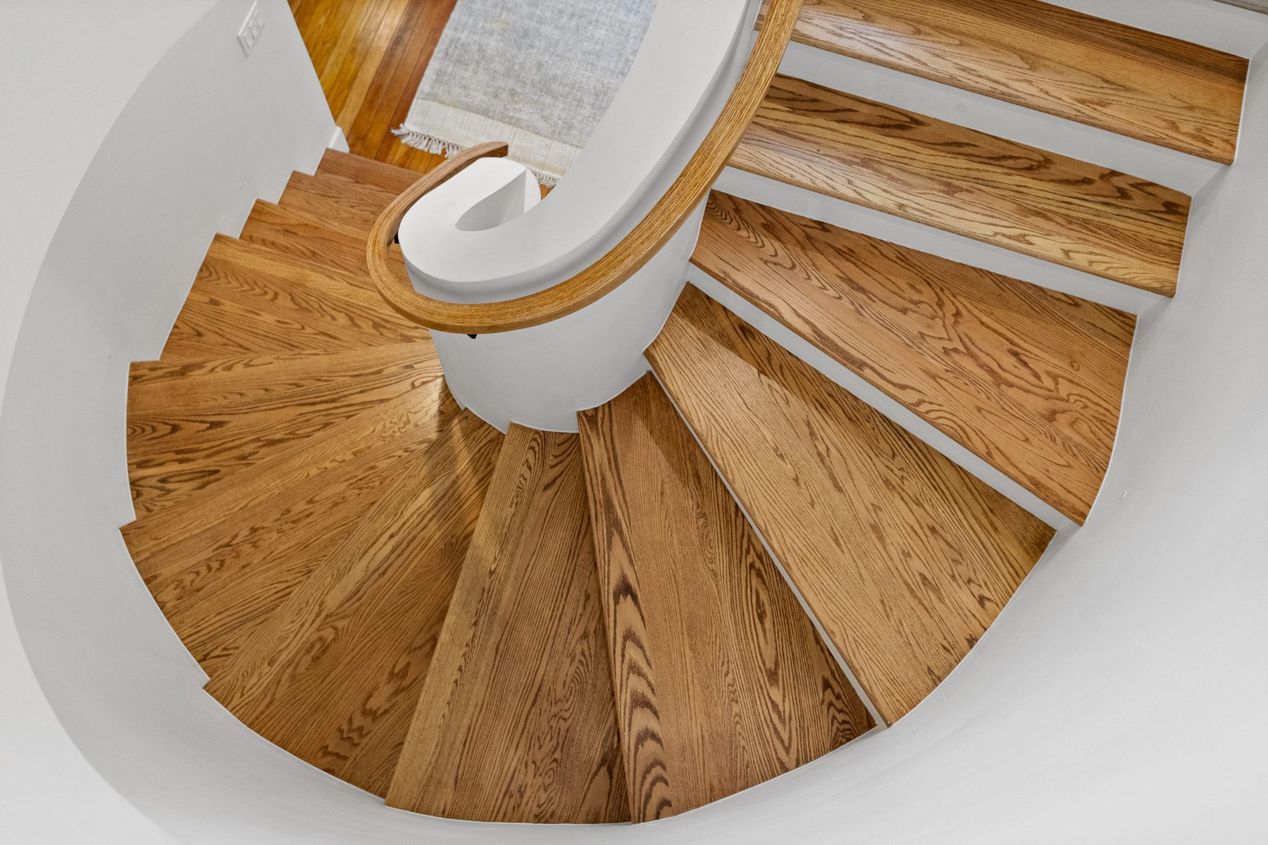 Sculptural curved white oak staircase in a restored Chattanooga home by James & Co.