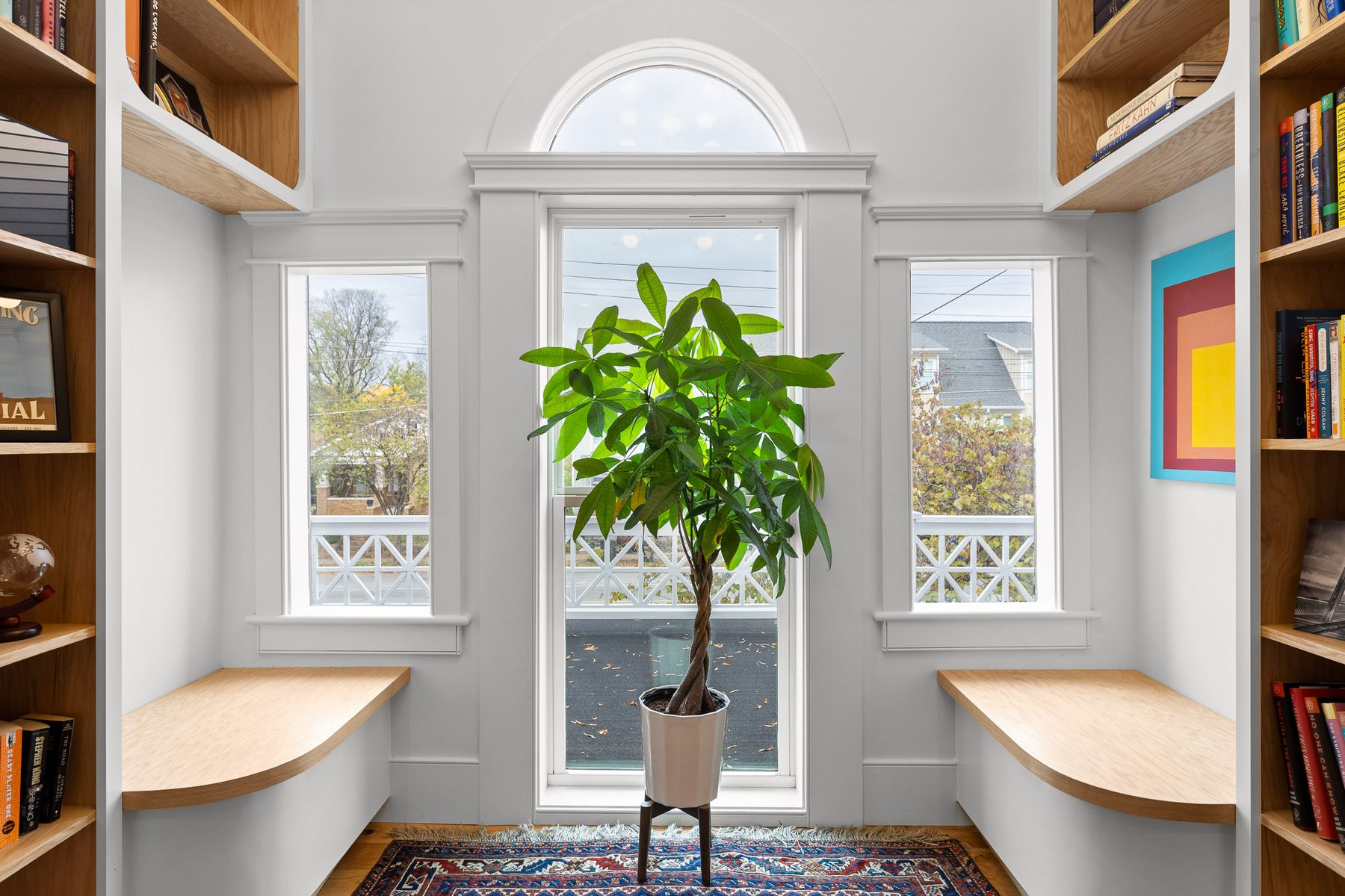 Built-in white oak reading nook with bench seating beside a bright window
