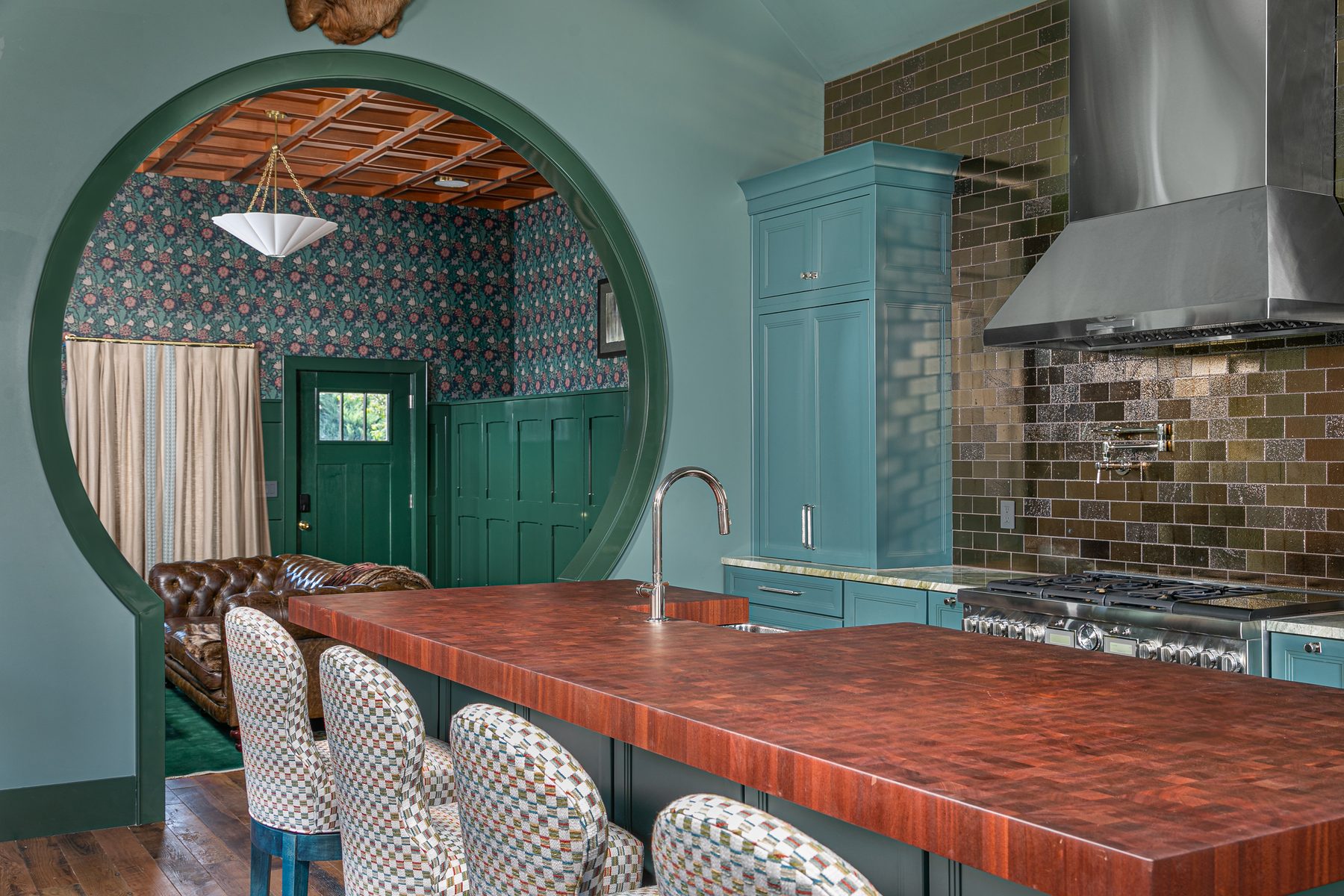 Kitchen with a copper countertop, moon-gate window and a stainless range under a custom hood