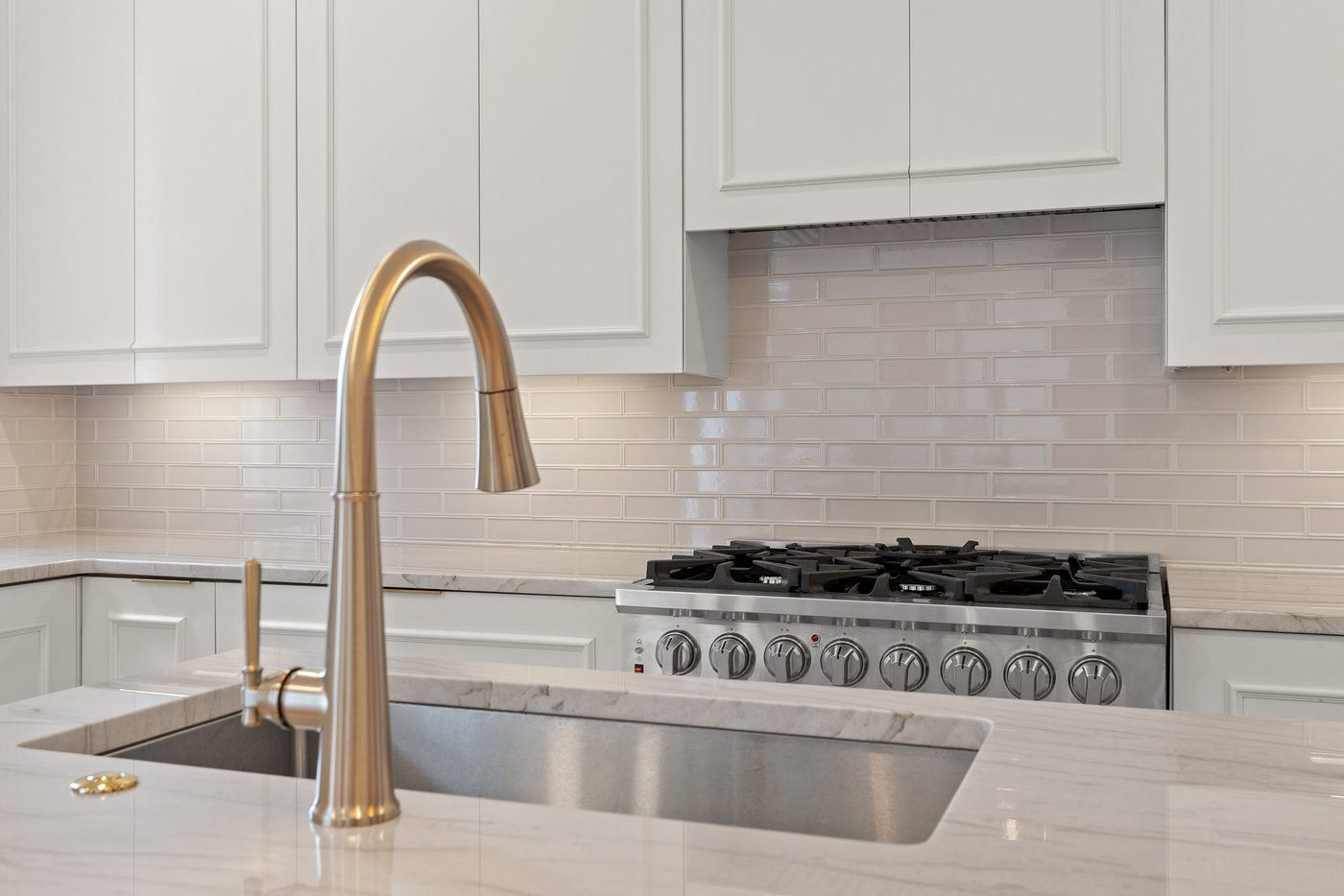 Custom kitchen island with brushed brass hardware and marble top